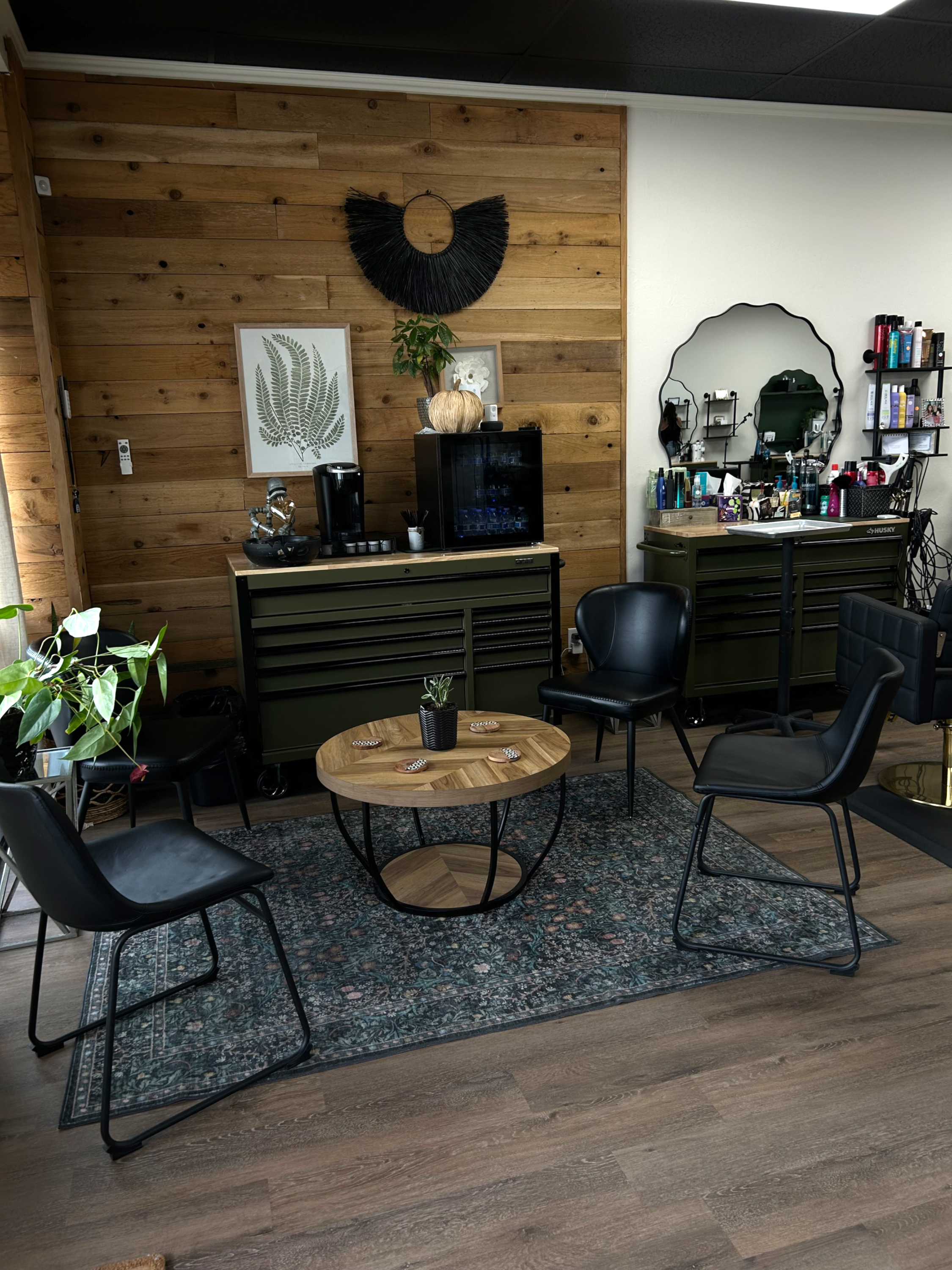 Cozy waiting area and styling stations with rustic wood accents at The Hair Collective hair salon in Oklahoma City